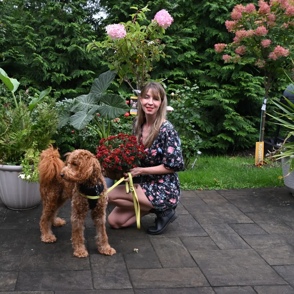 A woman and her dog visiting a flower nursery together